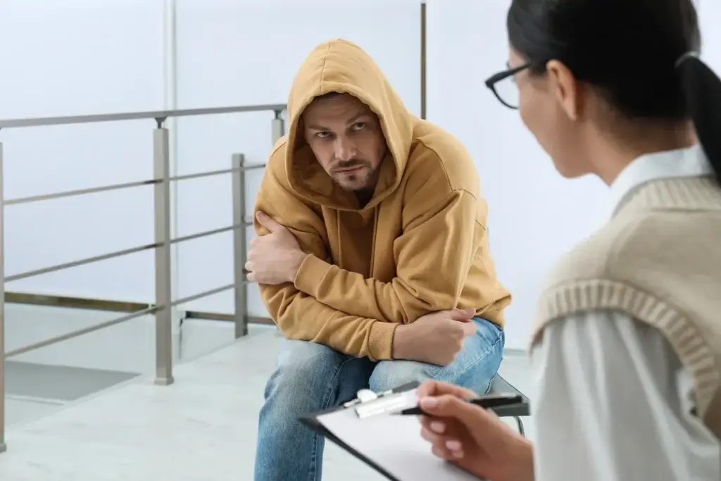 Man discussing his addiction with a therapist, highlighting the importance of seeking professional help for addiction and trauma.