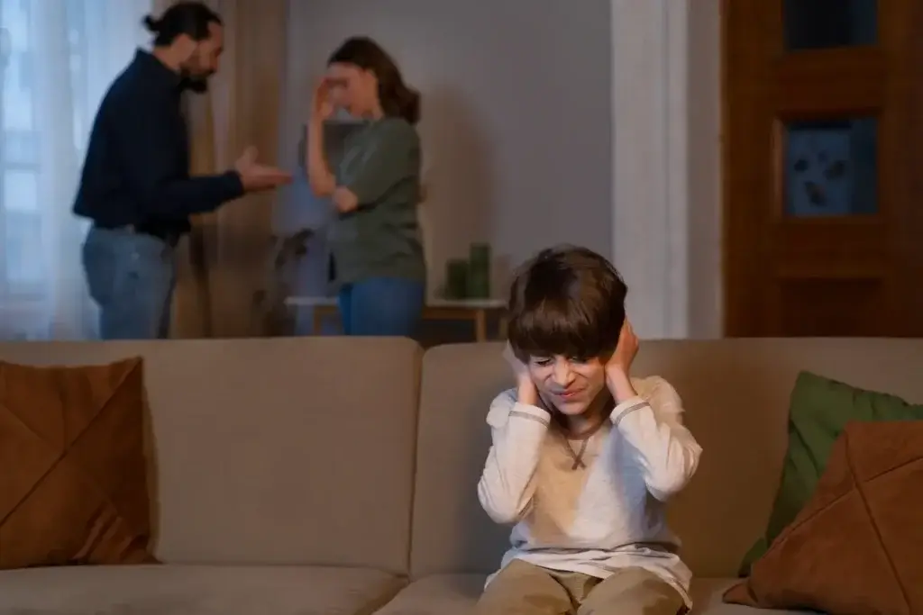 Young boy relaxing on a couch with his parents, reflecting a family dynamic shaped by anxiety