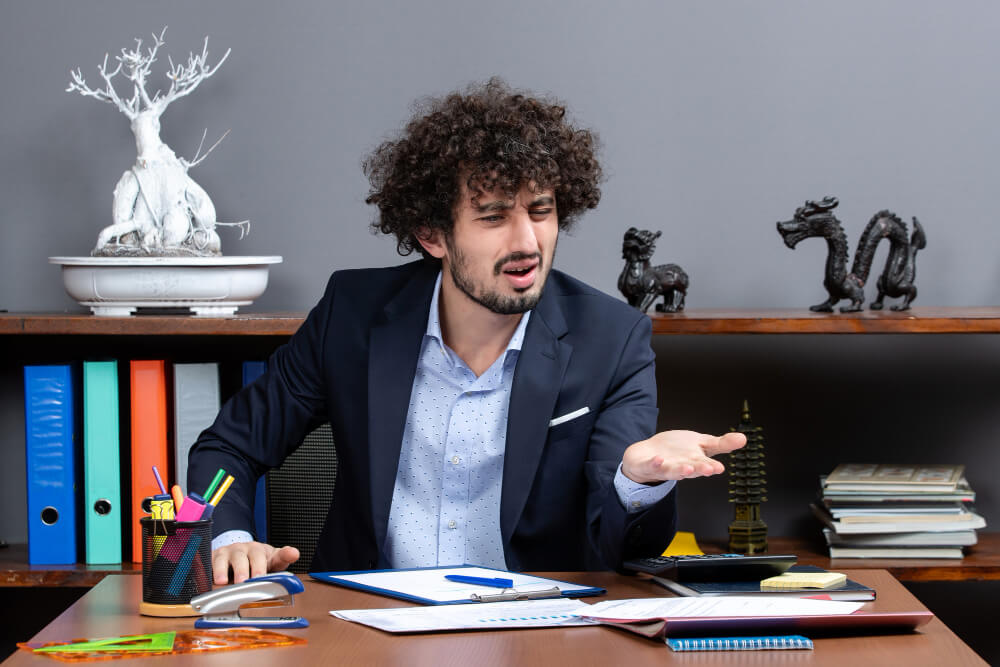Professional sitting thoughtfully at a desk, reflecting after making a mistake, demonstrating accountability and emotional regulation.