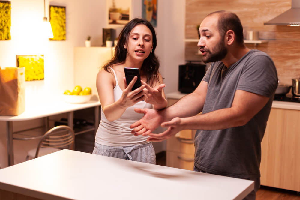 Couple sitting apart after a disagreement as emotional triggers and attachment fears make a small conflict feel overwhelming